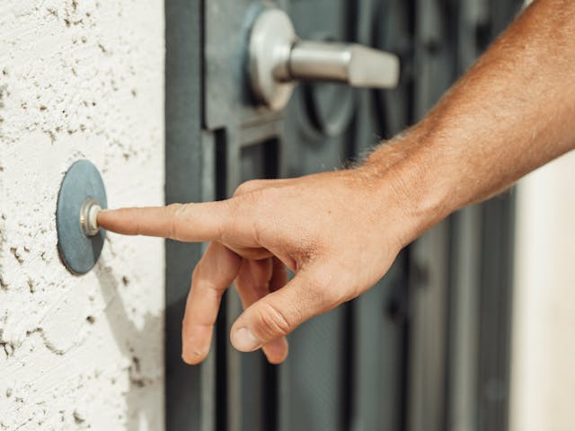 person pressing doorbell