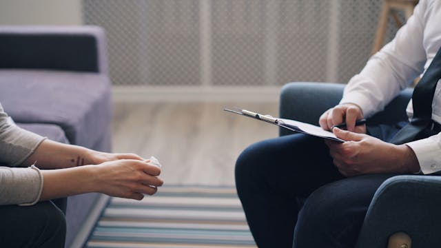 two people sitting with a clipboard