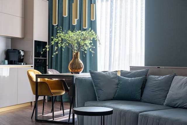 pale blue couch in front of table brightly colored accent decor